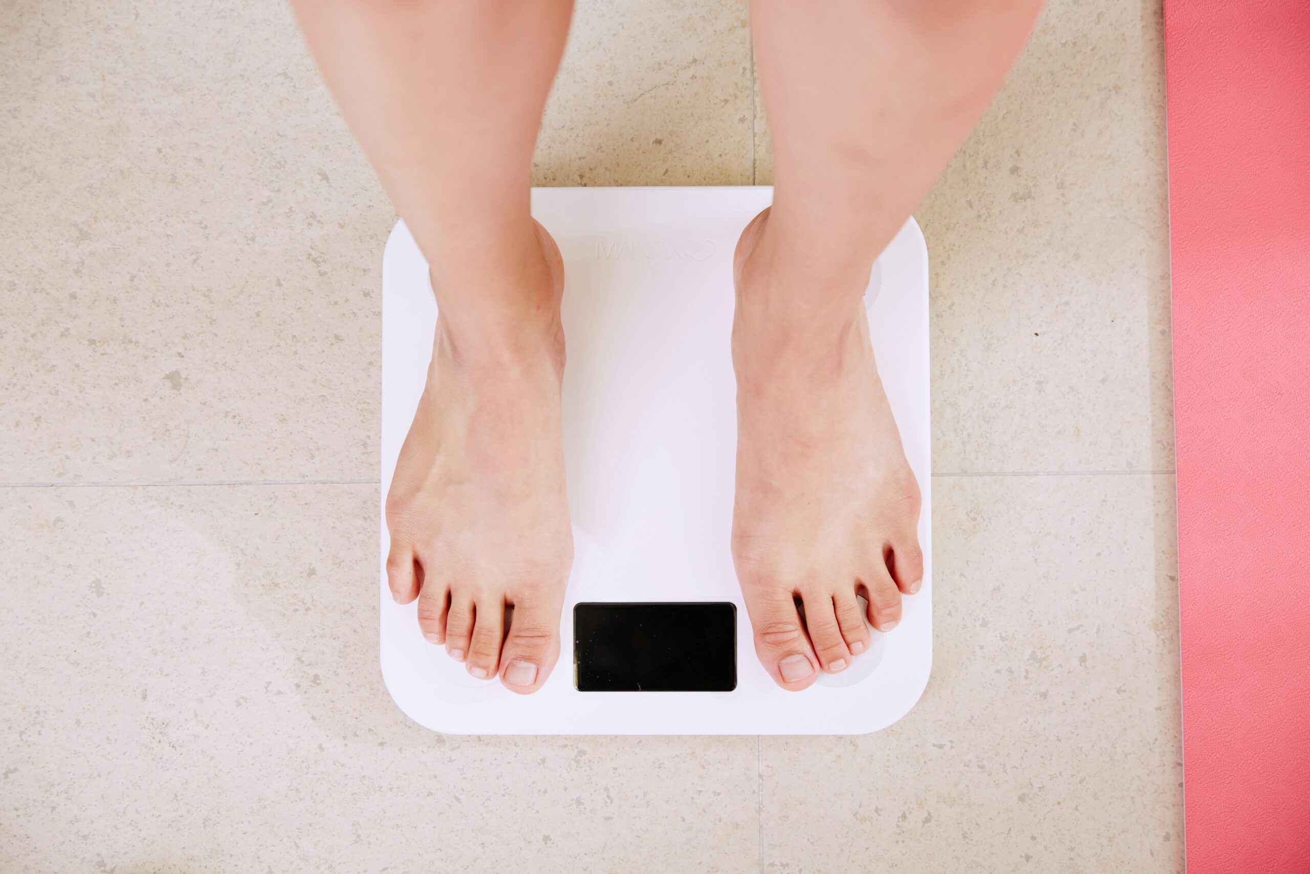person measuring waist with tape measure